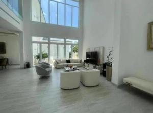 瓜亚基尔Alojamiento en Samborondon的大型客厅设有白色家具和大窗户