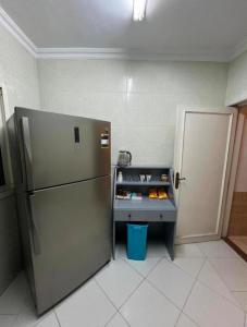 开罗Room for transit near airport的厨房配有冰箱和带食品的桌子。