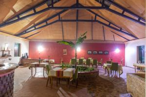 KashashaSharp Island Gorilla Lodge, Lake Bunyonyi的大楼内带桌椅的用餐室