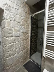 洛科罗通多Holiday Home Cosimo的带淋浴的浴室(带石墙)