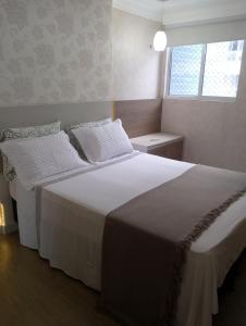 圣路易斯APARTAMENTO LUXUOSO A 1KM DA LITORÂNEA的卧室设有一张白色大床和一扇窗户。