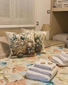 阿拉西奥Holiday Rooms La Campagnetta的配有一张床铺和一张桌子上的毛巾的房间
