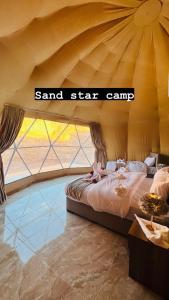 瓦迪拉姆Sand Star Camp的一间卧室设有一张大床和一个大窗户