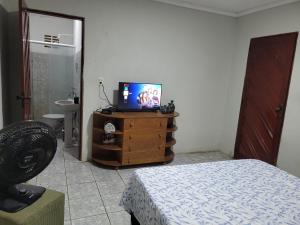 北茹阿泽鲁Quarto - Canto Juazeirense的卧室配有带电视的梳妆台和床