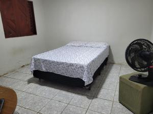 北茹阿泽鲁Quarto - Canto Juazeirense的一间带风扇的客房内一张床的卧室