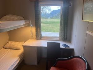 ByglandReiårsfossen Hostel & Camping的客房设有书桌、床和窗户。