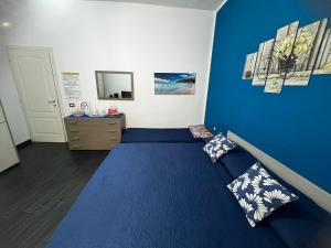 卡利亚里Affittacamere Sa Pardula的一间卧室拥有蓝色的墙壁,配有一张带枕头的床。