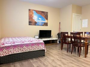 纳奈莫海岛度假屋的一间卧室配有一张床、一张桌子和一台电视