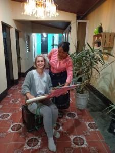 圣胡安拉拉古纳Hostal Sanjuanerita的两个女人在房间剪一条带子