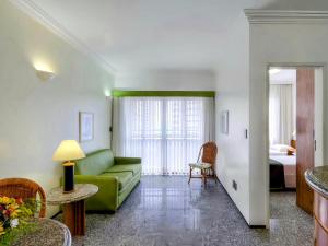 福塔莱萨Premium Flats - Tulip Inn的客厅配有绿色沙发和床。