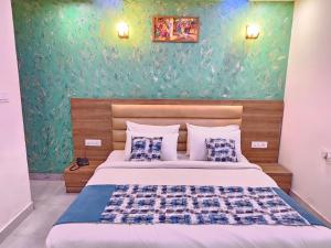 新德里Hotel MARISA GRAND Near Delhi Airport BY Aero Home的一间卧室设有一张床和绿色的墙壁