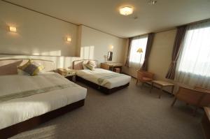 东广岛市广岛翼一区酒店的酒店客房配有两张床和一张书桌