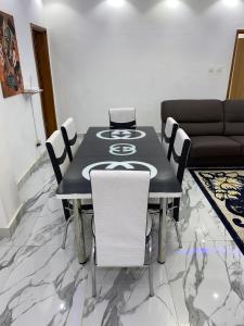 达喀尔Villas meublé yoff的一间用餐室,配有黑桌和白色椅子