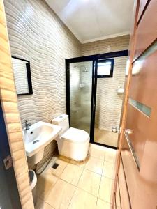 大雅台Sierra Pines Place Tagaytay的浴室配有卫生间、盥洗盆和淋浴。