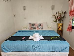 北碧Thai Garden​ Resort​ Kanchanaburi​的床上有一只塞满动物的睡床