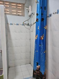 北碧Thai Garden​ Resort​ Kanchanaburi​的一间带蓝色淋浴帘的淋浴的浴室