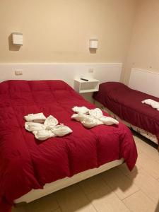 佩里托莫雷诺El viejo bar hotel的一间卧室配有两张带红色床单和毛巾的床。