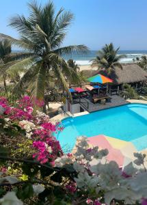 Santa María TonamecaBeachfront Paradise Boutique Hotel的棕榈树和海滩的游泳池