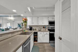 南帕诸岛Seagull Beachfront Condominiums的厨房配有白色橱柜、水槽和电器