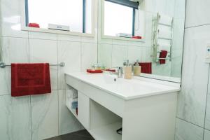 北帕默斯顿奥宾阁温泉汽车旅馆的白色的浴室设有水槽和镜子
