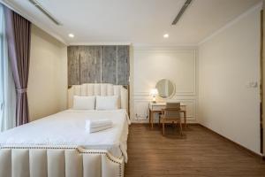 胡志明市Vinhomes Central Park - PHAN DANG Residences的卧室配有白色的床和桌子