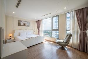 胡志明市Vinhomes Central Park - PHAN DANG Residences的卧室配有白色的床、椅子和窗户。