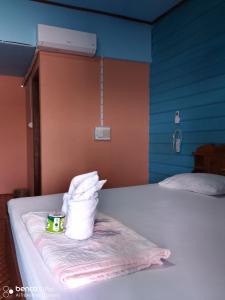 东德岛Namknong view的一张带一堆毛巾和一杯咖啡的床