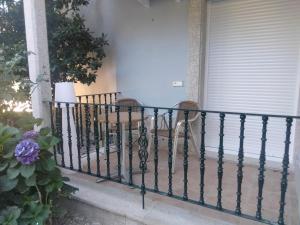 桑亨霍卡博费斯提纳匝酒店的门廊上的铁艺栏杆,带两把椅子