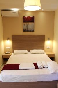 罗德镇费洛克贞尼亚一室公寓酒店的一间卧室配有一张大床和两条毛巾