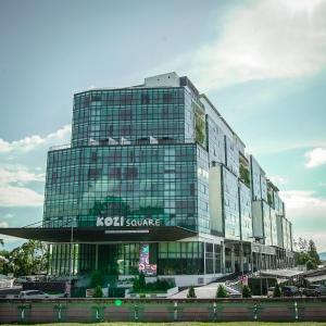 古晋Regatta Suites Hotel at Kozi Square Kuching的前面有Koci服务标志的建筑