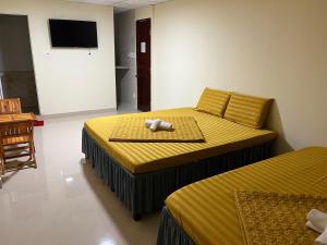 Cái RăngNhà Nghỉ Thiên Phú 2的一间卧室配有两张带黄床单的床