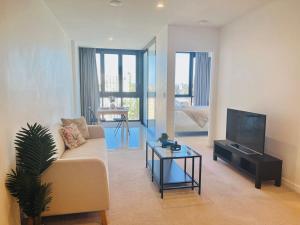 布里斯班CASSA TOOWONG - Convenient 1B Apt at Central Location with Parking Managed by The Cassa的带沙发和电视的客厅