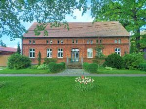BuchholzZur Alten Tabakscheune的一座带鲜花的院子的大型红砖房子