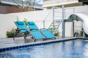 芭堤雅市中心Luxury 250sqm Pool Villa in Central Location 5min to Beach & Walking Street!的游泳池旁的一对蓝色椅子
