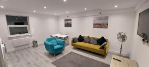 坎伯利Modern 2 Bedroom Apartments Town Centre Camberley的客厅配有黄色沙发和蓝色椅子