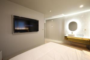 昌原市Changwon Denbasta Hotel Myeongseo的卧室配有壁挂式平面电视
