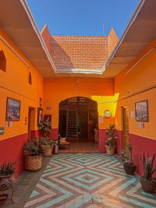 克雷塔罗克雷塔罗RJ酒店的一座拥有橙色墙壁和瓷砖地板的建筑