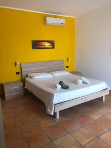 切萨雷奥港Oasi的一间卧室设有一张黄色墙壁的大床