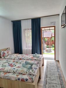 瓦杜伊泽Pensiunea Casa Ancuta的一间卧室配有一张带蓝色窗帘的床和一扇窗户