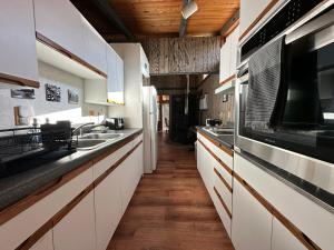 帕克伍德The Cabin in Packwood的厨房配有白色橱柜和木制天花板