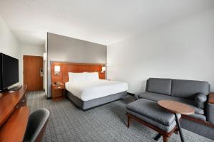 德卢斯亚特兰大德卢斯/格威内特广场万怡酒店的一间酒店客房,配有一张床和一台电视