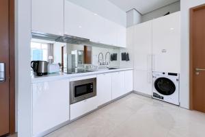 吉隆坡吉隆坡会展中心勒雅拉套房公寓的厨房配有白色橱柜、洗衣机和烘干机