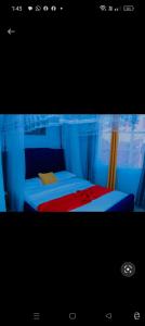 KisiiGreenstar home的一间卧室配有一张带红色毯子的床