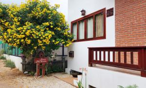 恰洛克拉姆Baan Bhuwann Holiday Apartment的一座建筑物旁的黄色花树