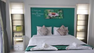 卡塔海滩Phuket Racha Kata Homestay的一间卧室设有一张大床和绿色的墙壁