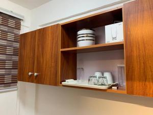 库马西Modern Cozy 1Bedroom Space near KNUST & Kumasi Airport的厨房配有带盘子和玻璃杯的木制橱柜