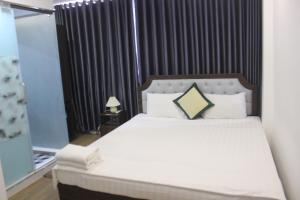 河内Hanoi Little Hotel的卧室配有一张带白色床单和枕头的大床。