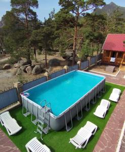 博罗沃耶Goluboy Zaliv的一个带躺椅的游泳池和一个泳池景