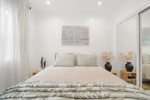 蒙特贝罗Cozy & Dreamy Getaway !的一间白色卧室,配有一张大床和两瓶花