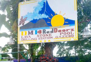 BaranghauonDMI Hotels and Apartments, Tabaco City Albay by RedDoorz的挂在建筑物前树上的标志